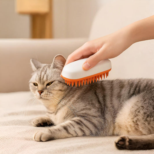 Handheld silicone pet grooming brush gently removing loose hair from a cat